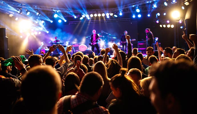 Crowd enjoying a live concert with lights and stage performance